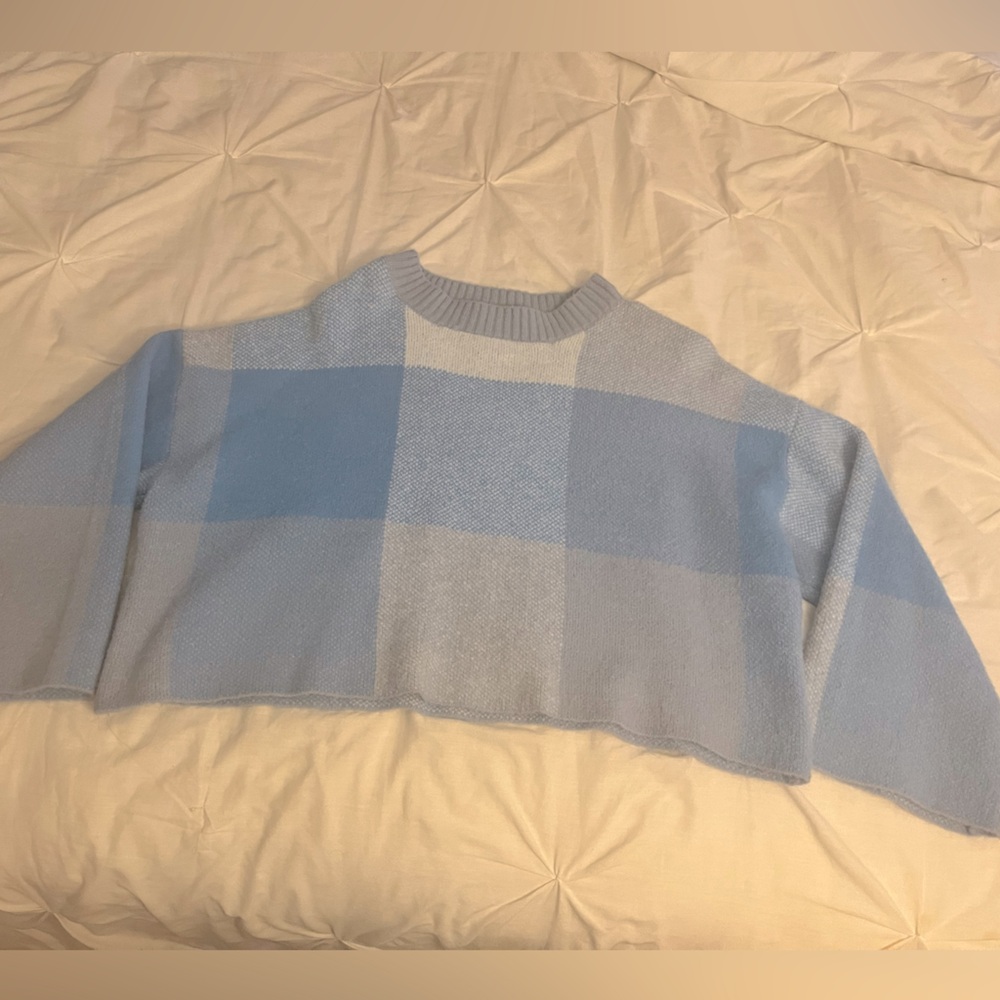 It’s a mainly blue sweater by the brand Jessica Simpson.